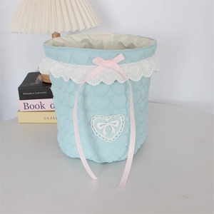 Detailed close-up of light blue heart quilted storage basket with lace and pink ribbon