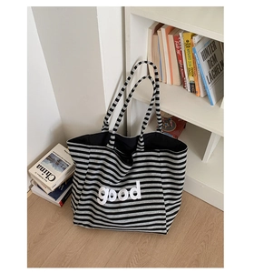 Close-up of the black and white striped canvas tote bag with good letter embroidery