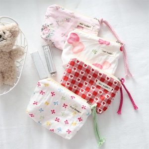 Close-up of small bow knot fabric organizers in four patterns with colorful zippers
