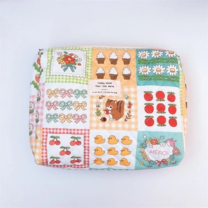 Detail of floral quilted cotton makeup bag with colorful animal prints and pink zipper