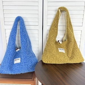 Detail of plush reversible tote bag with fuzzy texture and SEE YOU woven label