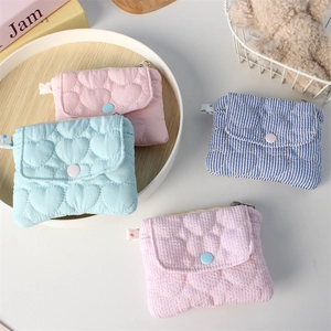 Detailed view of quilted heart coin purses in pink, blue, striped, and plaid cotton fabric
