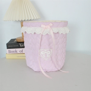 Detailed view of pink quilted lace storage basket with ribbon bow and heart pattern