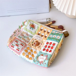 Macro shot of quilted cotton makeup bag with colorful patchwork patterns and white zipper