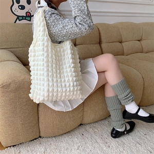 Detail of creamy white popcorn texture on large shoulder tote bag with soft fabric