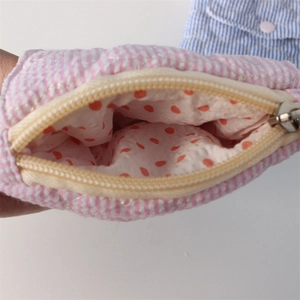 Detail of quilted heart coin purse showing striped fabric and polka dot lining textures