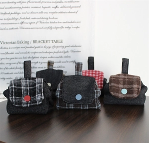 Detailed view of mini denim coin purses with colorful buttons in five plaid patterns