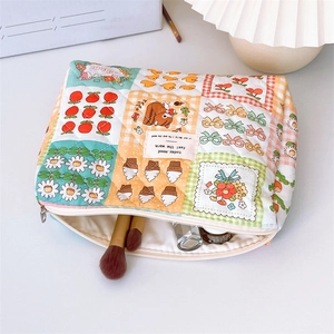 Close-up of a quilted floral makeup bag with bear patterns and colorful patchwork detail