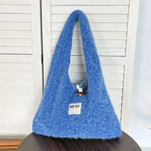 Detail of sky blue plush shoulder bag with horn buckle and checkered lining texture