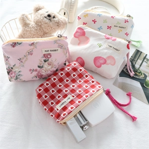 Close-up of four floral and heart pattern mini canvas pouches with zip closure and lanyards