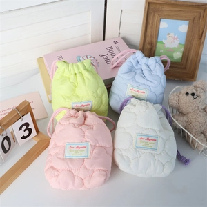 Close-up of heart-quilted drawstring pouches in pastel colors with decorative labels