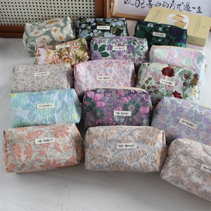 Flat lay of vintage floral jacquard pouches with metal zippers and fabric labels