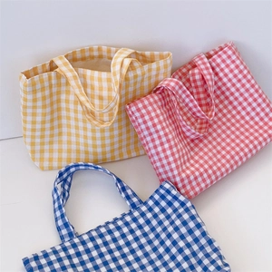 Detailed view of three colorful gingham tote bags in red blue and yellow cotton canvas