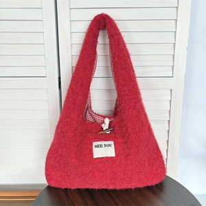 Detail of red plush tote bag with SEE YOU patch and wooden toggle closure