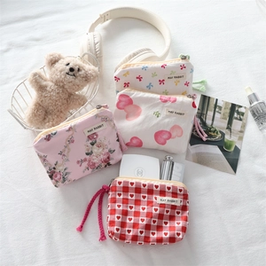 Flat lay of small canvas pouches with floral and heart patterns for earbuds or coins