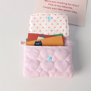 Detail of heart quilted coin purse with pink checkered fabric and blue snap button