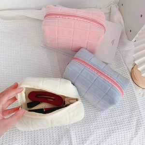 Detailed view of three quilted velvet storage bags in pink blue and white colors