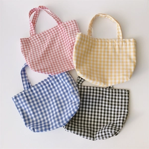 Flat lay of small gingham lunch bags in red, yellow, blue, and black checkered cotton
