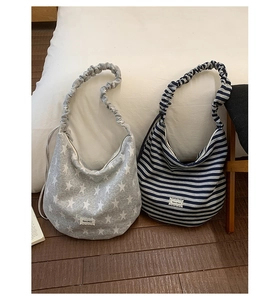 Detail of crescent hobo bags in star print and stripes with scrunchie straps and embroidery