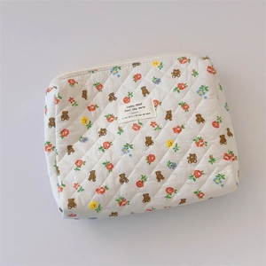 Detailed view of floral cotton quilted makeup bag with teddy bear pattern and zip closure