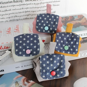 Detail of four colorful corduroy mini pouches with star pattern flaps and snap buttons