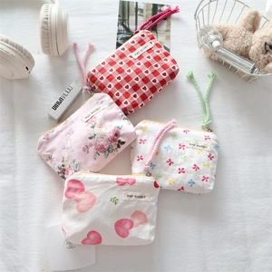 Close-up of canvas mini storage pouches with bow patterns and zipper lanyards