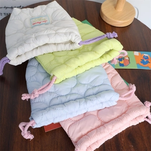 Close-up of heart quilted macaron drawstring bags in soft padded protective fabric