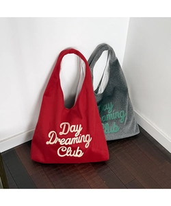 Close-up of wool tote bags with Day Dreaming Club embroidery in red and grey colors