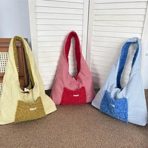 Close-up of three checkered plush tote bags in yellow, red, and light blue tones