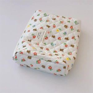 Macro view of floral quilted cotton makeup bag showing texture and stitching details