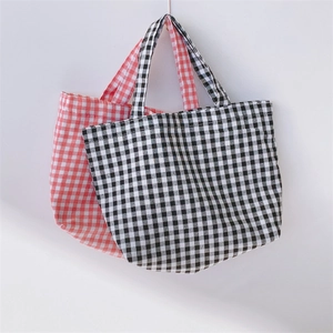 Detailed view of woven fabric texture on red and black plaid portable lunch tote bags