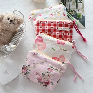 Detailed view of mini fabric pouches featuring bow patterns and woven pull strings