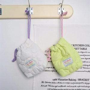 Detailed close-up of quilted heart-patterned drawstring storage bags in white and light green