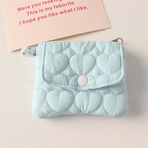 Close-up of heart-shaped quilted coin purse with light blue texture and snap button
