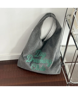 Detail of dark grey wool felt tote bag featuring green Day Dreaming Club embroidery