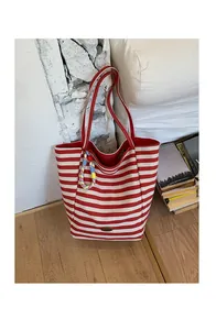 Gros plan du sac cabas en toile à rayures rouges et blanches avec cordon arc-en-ciel
