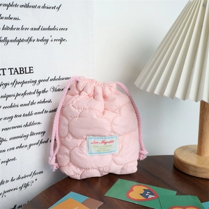 Close-up of pink quilted drawstring storage bag with Love Mayrabbit woven label