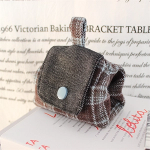 Detail of vintage tweed and denim mini pouch with button closure and top handle strap