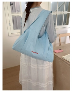 Close-up of light blue tote bag with GoodThing embroidery and spacious casual design