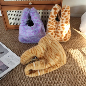 Plush animal print handbags in purple leopard and giraffe patterns on a brown rug