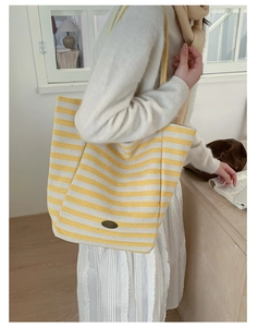 Détail du sac cabas en toile à rayures jaunes et blanches avec étiquette fait main