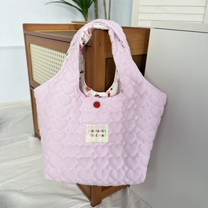 Detailed view of pink quilted heart tote bag with stripe pattern and soft fabric texture