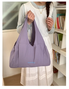 Close-up of a large purple tote bag with GoodThing lettering and reinforced handles