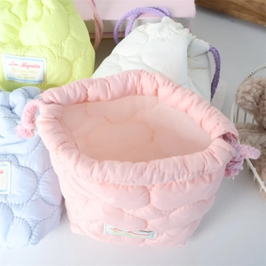 Detailed view of colorful quilted drawstring storage pouches with soft padding and embroidery