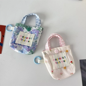 Détail de pochettes à fleurs pour écouteurs avec mousquetons en plastique et pressions