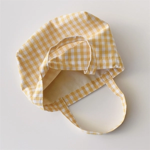 Detailed view of yellow and white gingham canvas fabric and sturdy tote bag handles