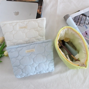 Quilted cloud cosmetic bag with zip closure showing interior makeup storage details