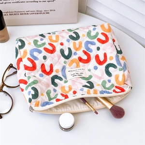 Detailed macro view of quilted floral cotton makeup bag with colorful U-shaped pattern prints