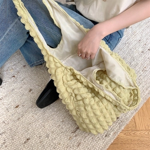 Detail of light yellow bubble texture tote bag with cream fabric lining and inner pocket