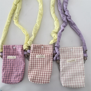 Detailed view of plaid fabric mini bags with ruffled straps and snap button closures